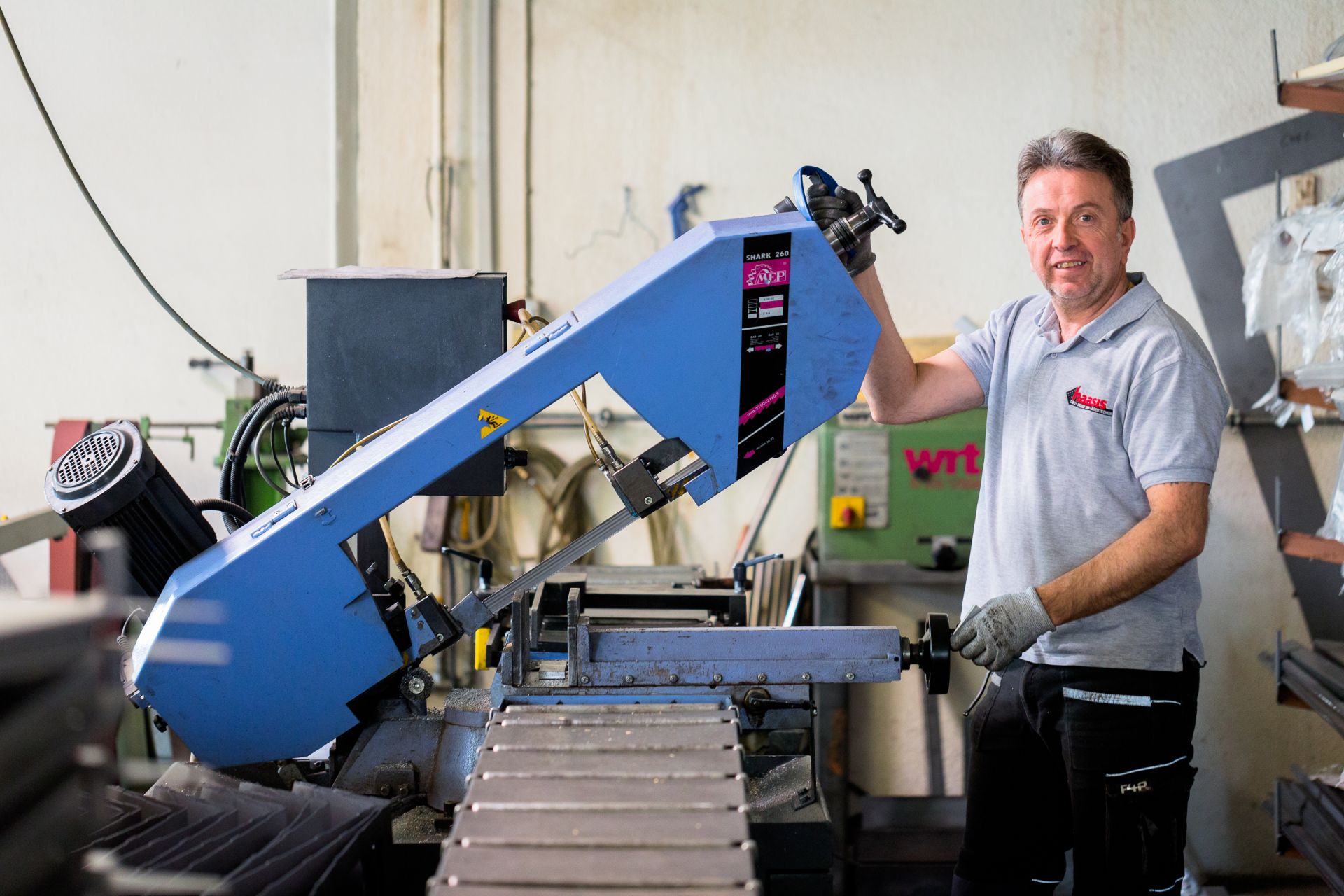 Ein Mitarbeiter von Haasis Bleche bearbeitet ein Metallteil an einer großen Maschine